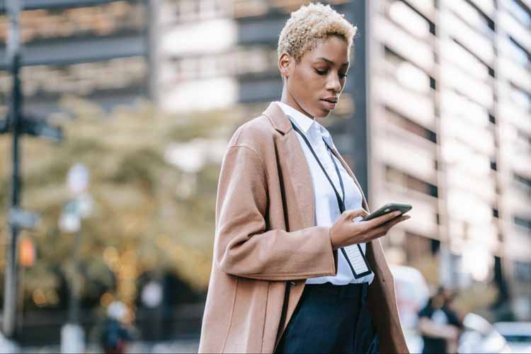 Femme dans la rue tenant un telephone